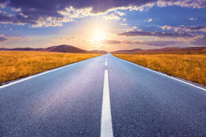 Carefree driving on an empty road at sunset